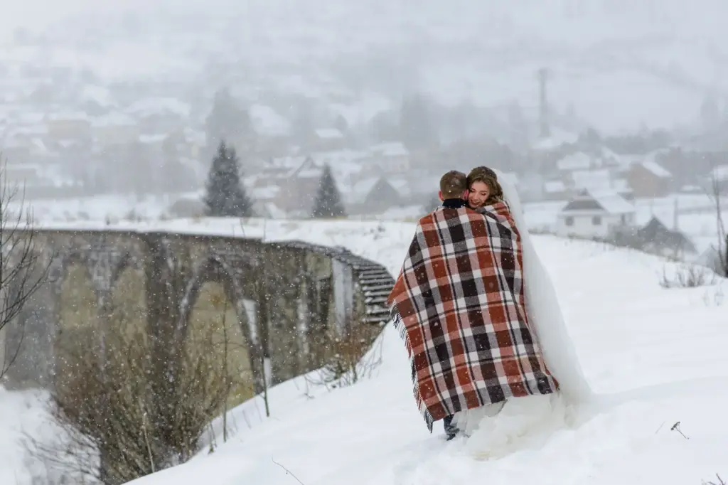 Snuggling under a shared blanket with snowflakes