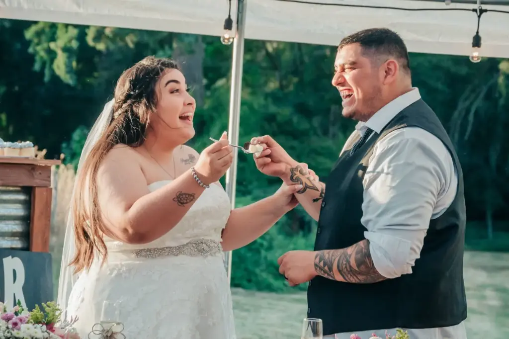 The groom feeds cake to the bride playfully