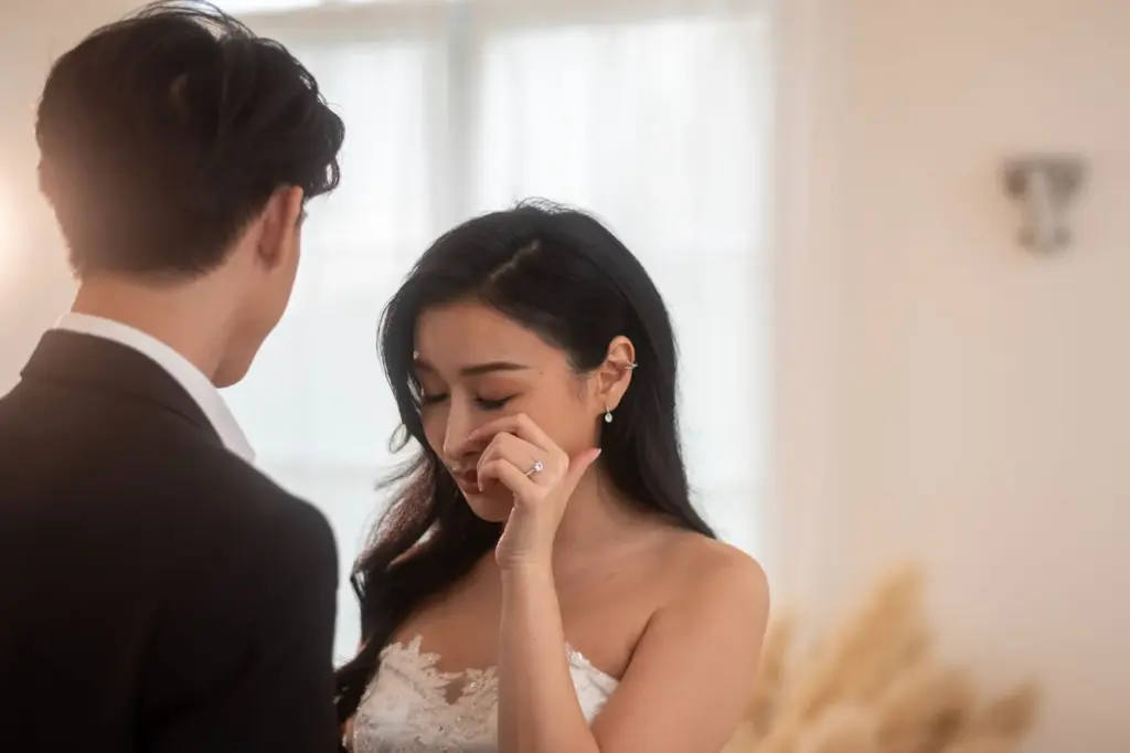 Wiping a tear with a quick, emotional gesture