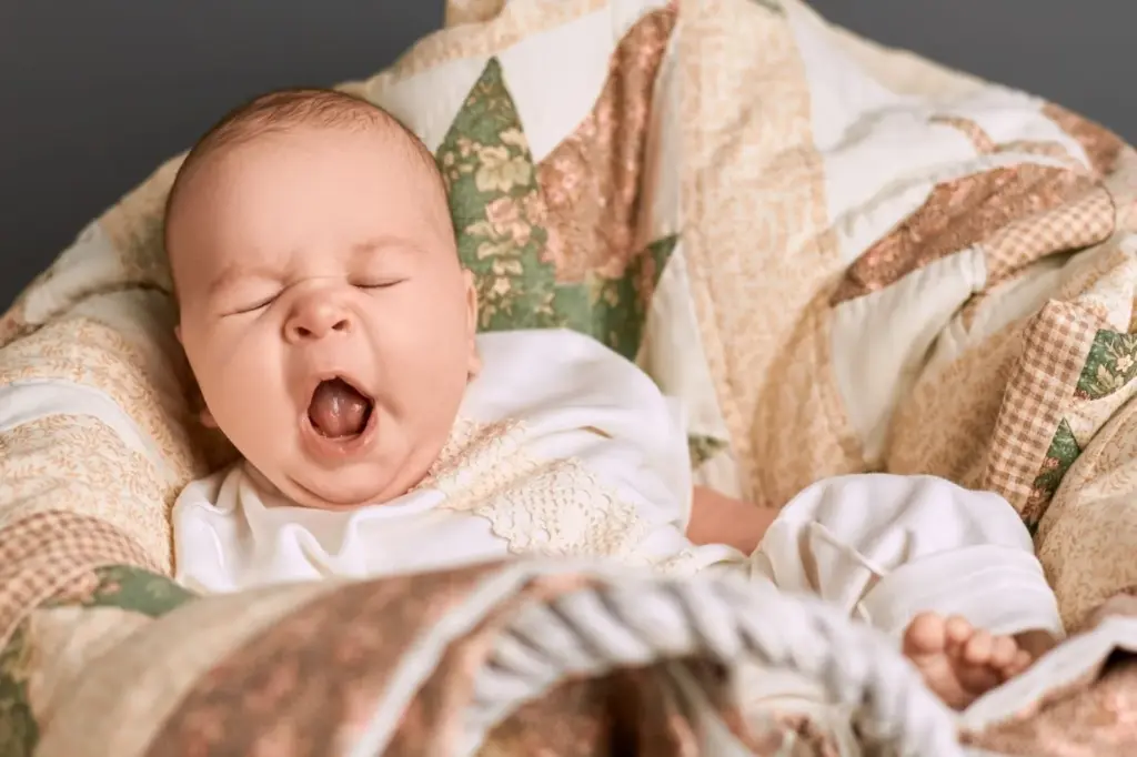 Yawning while wrapped in a blanket
