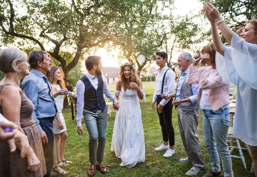 20+ Creative Group Wedding Photo Ideas for Family and Friends 19 Bride, Groom And Guests At Wedding Reception Outside In The Backyard