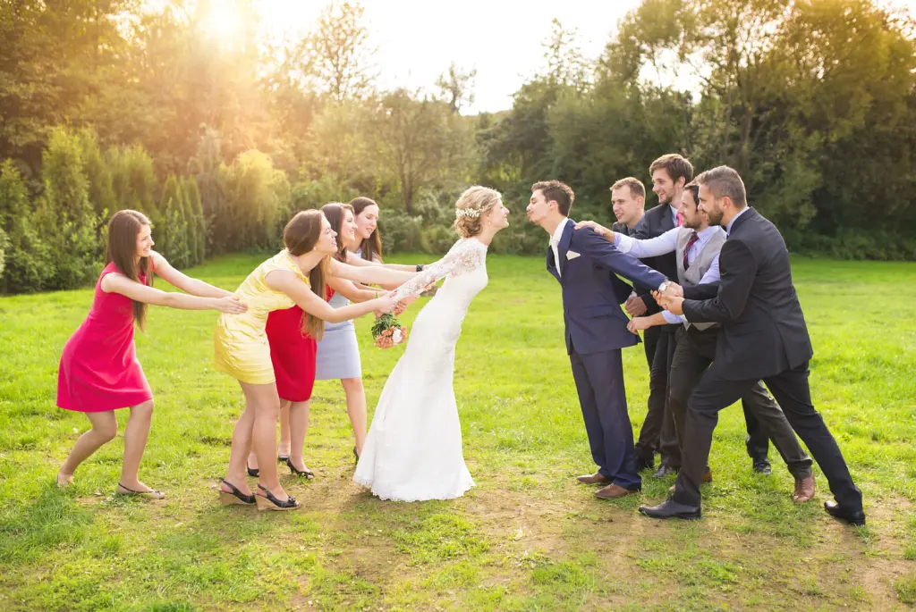20+ Creative Group Wedding Photo Ideas for Family and Friends 29 Bridesmaids and Groomsmen Pulling the Newlyweds Together
