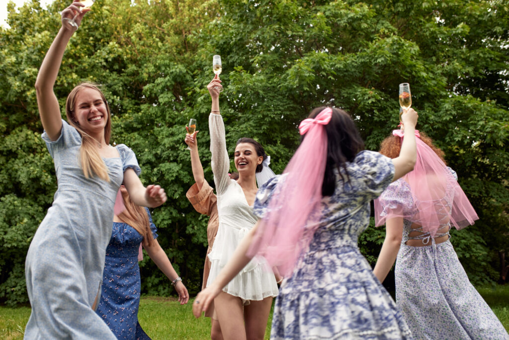 20+ Creative Group Wedding Photo Ideas for Family and Friends 74 Bride-To-Be Celebrating with Her Bridesmaids in a Festive Outdoor Gathering