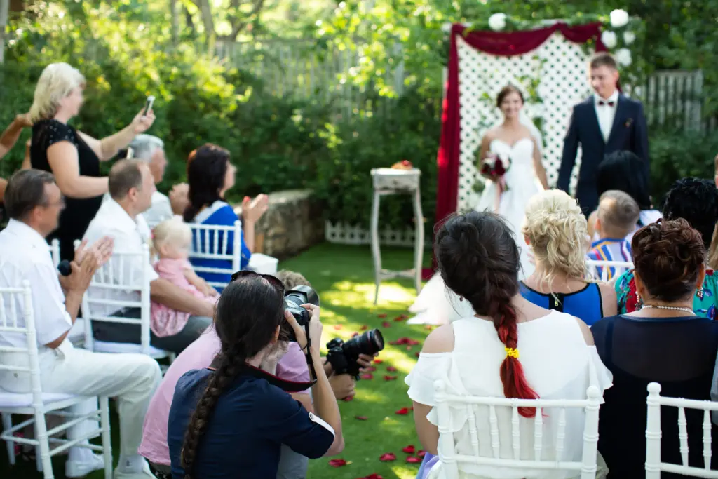 20+ Creative Group Wedding Photo Ideas for Family and Friends 61 Photographer is a woman photographing a wedding ceremony