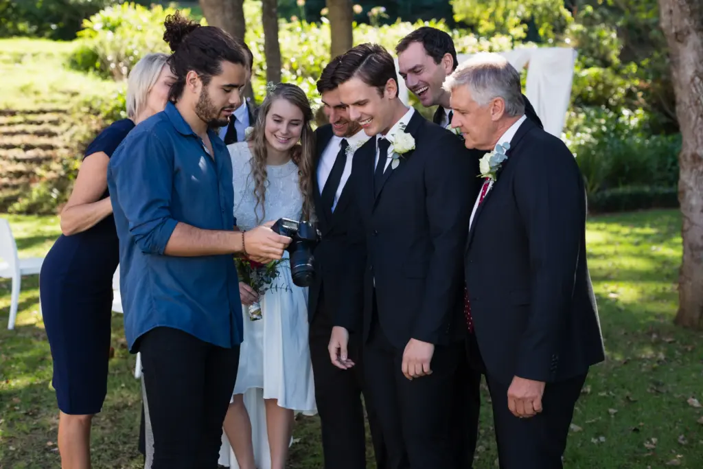 20+ Creative Group Wedding Photo Ideas for Family and Friends 62 Photographer reviewing photographs on digital camera